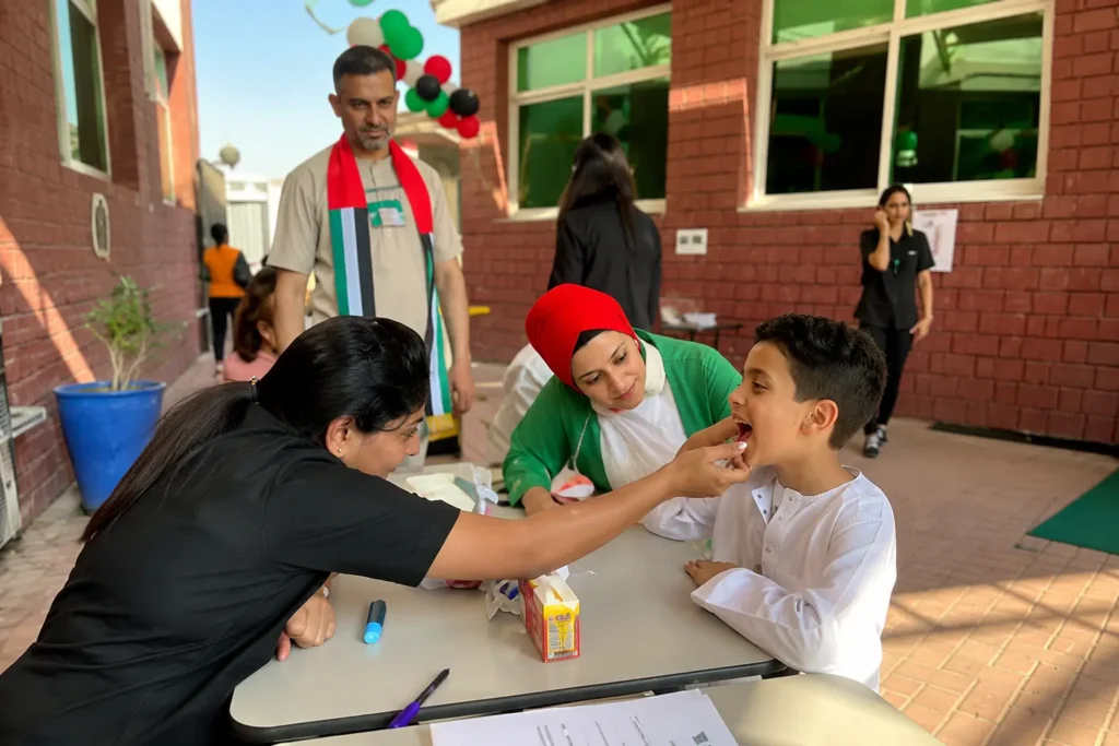 Crossroads Dental Clinic team conducting a children's dental screening and oral health awareness activity at the Deira Private School Grand UAE National Day Carnival 2022 in Dubai.