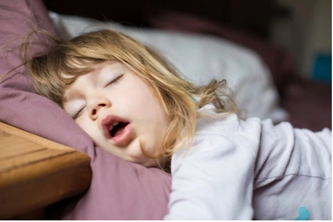 Child mouth breathing during sleep indicating possible airway obstruction or sleep apnea issues